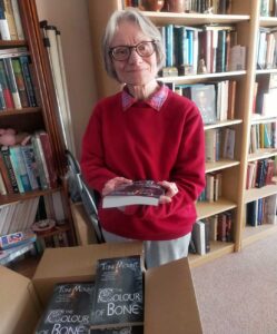 Toni Mount holding her book "The Colour of Bone"